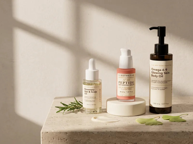 L'ESTHETIQ Rosemary Hair & Scalp Oil, Peptide Anti-Ageing Serum and Omega 6-9 Body Oil on a travertine console