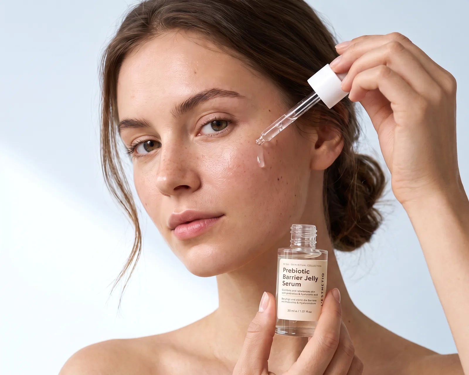 Woman applying Prebiotic Barrier Jelly Serum with a dropper